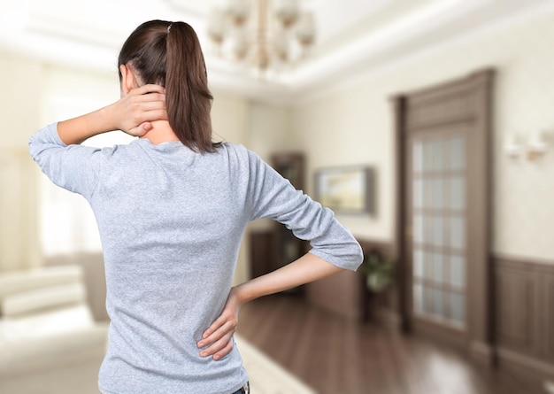 Une femme mature contrariée souffrant de maux de dos après avoir dormi en frottant des muscles raides.