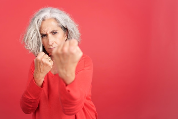 Femme mature face à la caméra avec ses poings