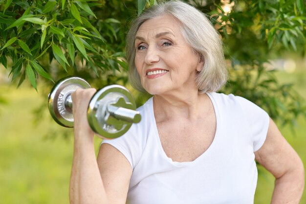 Femme mature avec haltère dans un parc