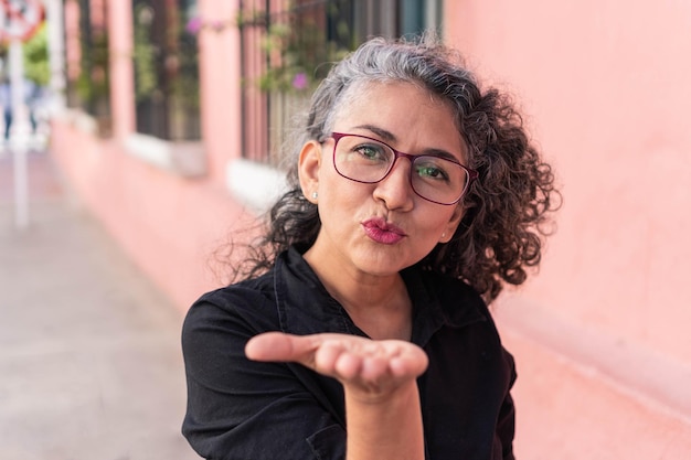 Femme mature à lunettes posant dans la ville