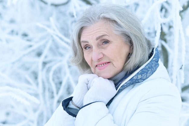 Femme mature en vêtements d'hiver posant à l'extérieur, de bonne humeur