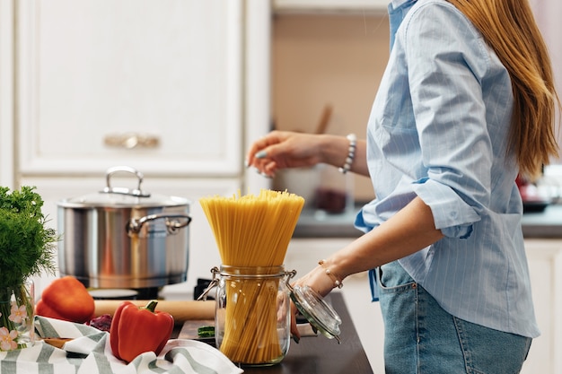 Femme méconnaissable, cuisine dans sa cuisine se bouchent