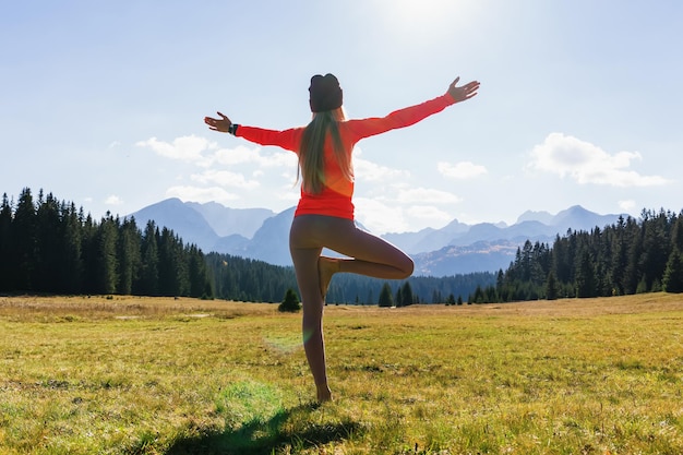 Femme méconnaissable pendant la pratique du yoga avec vue sur la montagne le matin