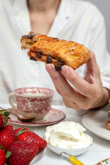 Femme méconnaissable prenant son petit déjeuner en pyjama à la maison