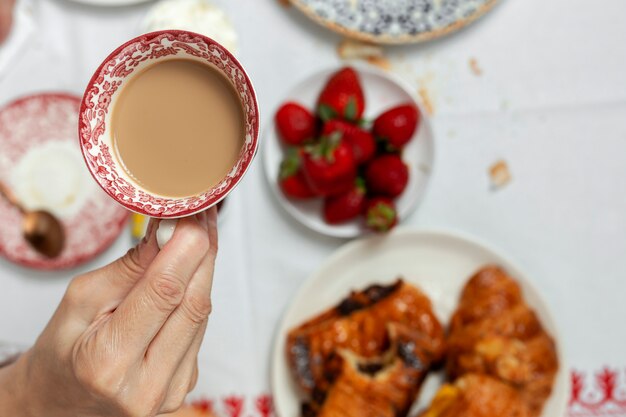 Femme méconnaissable prenant son petit déjeuner en pyjama à la maison