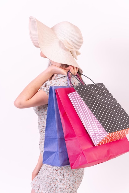 Femme méconnaissable tenant des sacs à provisions sur le concept de vente de fond blanc