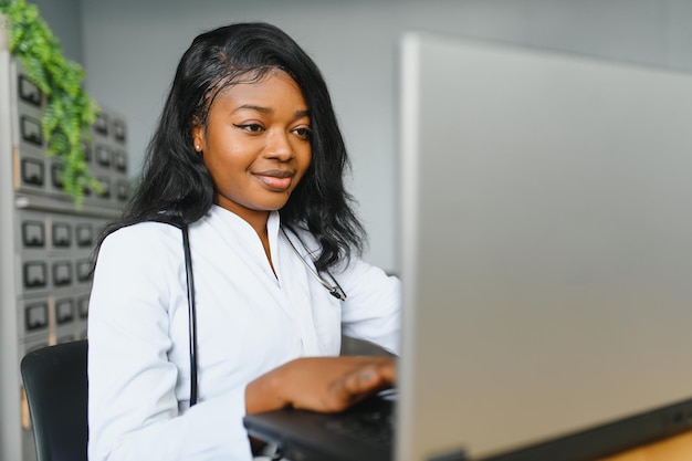Femme médecin africaine parler avec le patient faire un appel vidéo webcam en ligne de télémédecine Femme thérapeute vidéoconférence sur ordinateur dans le chat virtuel d'ordinateur portable de télémédecine à distance Concept de télésanté