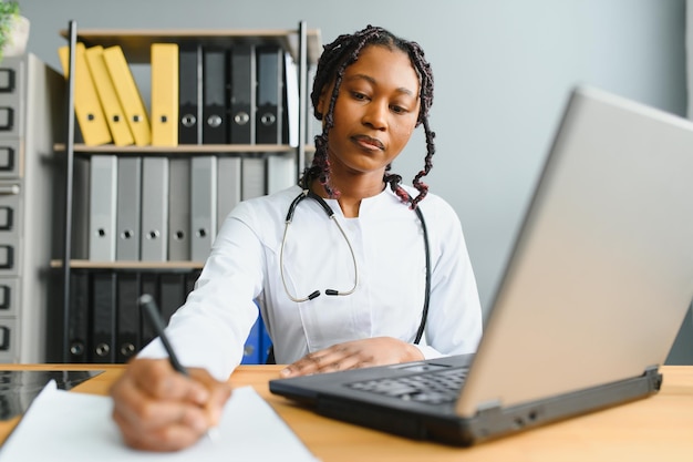 Femme médecin africaine parler avec le patient faire un appel vidéo webcam en ligne de télémédecine Femme thérapeute vidéoconférence sur ordinateur dans le chat virtuel d'ordinateur portable de télémédecine à distance Concept de télésanté