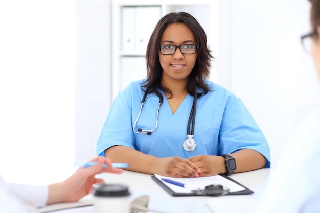 Femme médecin afro-américaine avec un collègue à l'hôpital