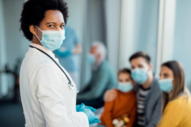 Femme médecin afro-américaine portant un masque protecteur dans le couloir de l'hôpital