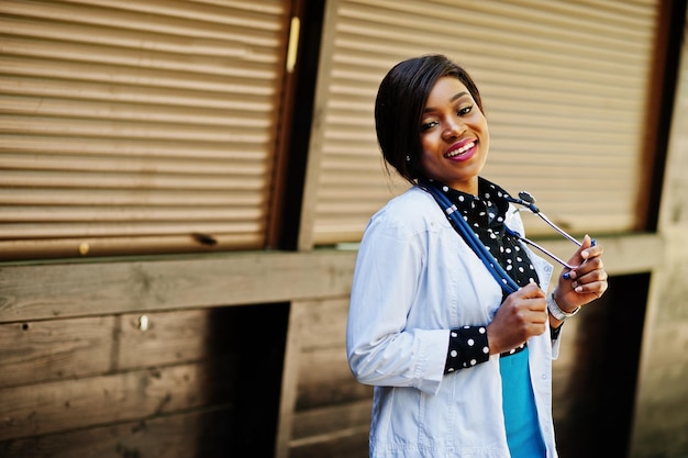 Femme médecin afro-américaine avec stéthoscope posé en plein air