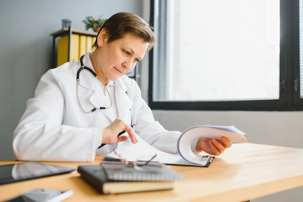 Femme médecin d'âge moyen écrivant une ordonnance