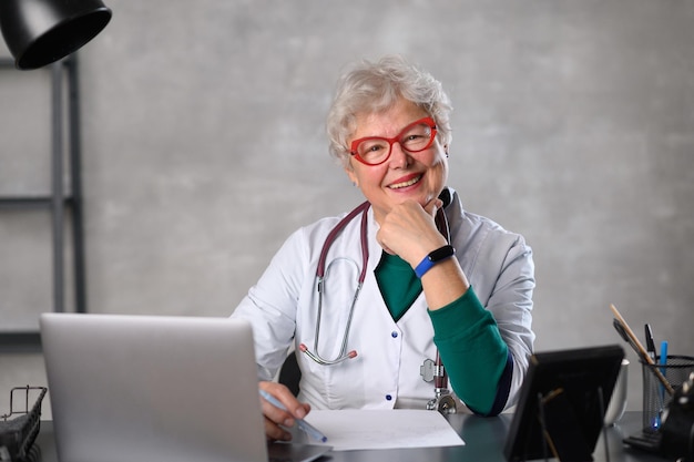 Femme médecin d'âge moyen souriante regardant la caméra heureuse vieille dame élégante mature posant à l'hôpital