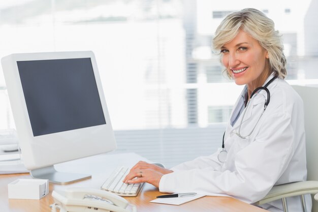 Femme médecin à l&#39;aide d&#39;ordinateur au bureau dans le cabinet médical