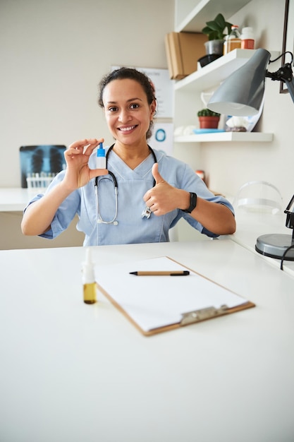 Femme médecin approuvant les gouttes nasales avec un pouce levé