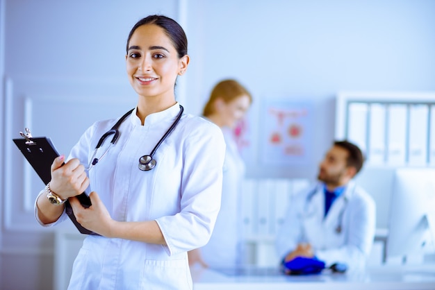 Femme médecin arabe debout devant son équipe à l'hôpital