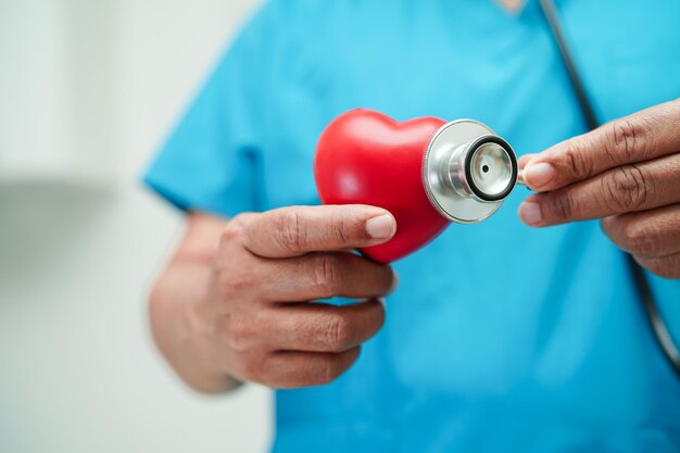 Femme médecin asiatique tenant un coeur rouge pour la santé à l'hôpital