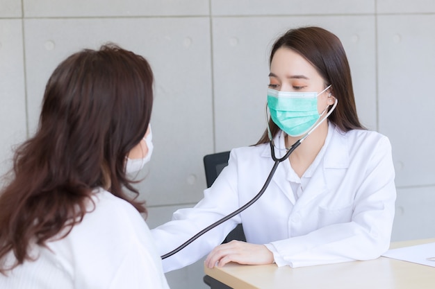 Une femme médecin asiatique utilise un stéthoscope pour vérifier la santé des poumons et du cœur ou un symptôme de diagnostic de la femme