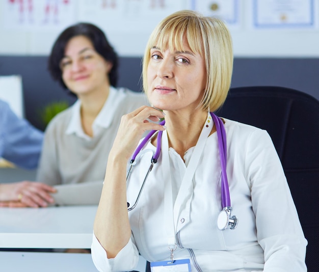 Femme médecin assise avec un patient masculin au bureau