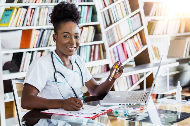 Femme médecin en blouse blanche tenant un tube à essai sanguin