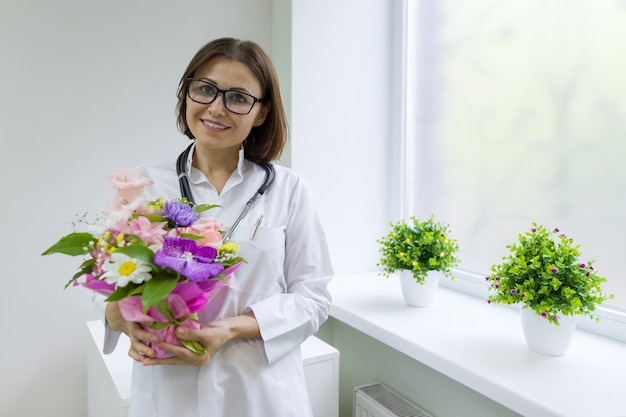 Femme médecin avec bouquet de fleurs