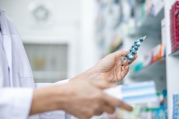 Femme médecin avec capsule médecine packs sur la main dans la pharmacie Thaïlande