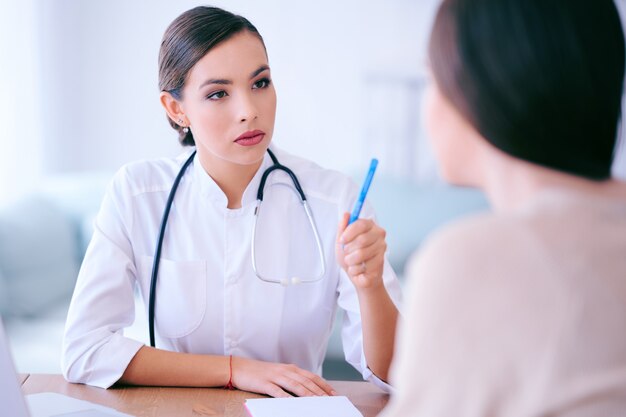 Femme médecin communique avec le patient au bureau et prescrit des médicaments