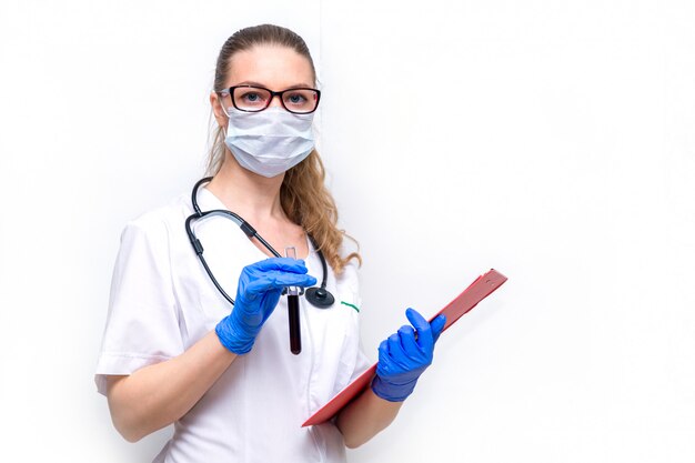 Une femme médecin dans un masque de protection avec un tube à essai dans ses mains sur blanc