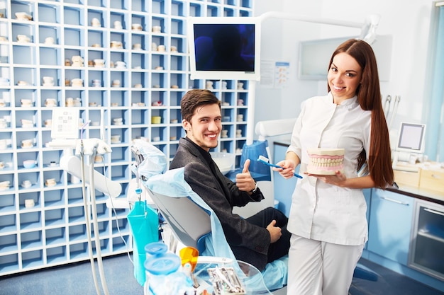 Femme médecin dentiste professionnel travaillant Homme à la clinique dentaire homme au dentiste prenant soin des dents