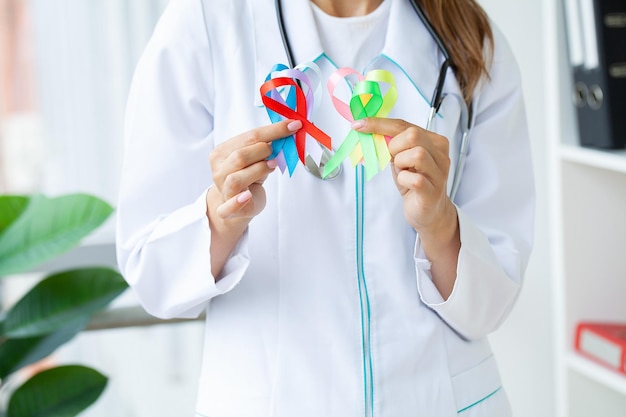 Une femme médecin détient des rubans colorés symbolisant la prise de conscience de diverses maladies