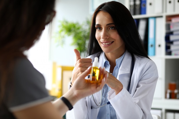 Femme médecin donnant au patient un compte-gouttes d'huile de concentré de cannabis