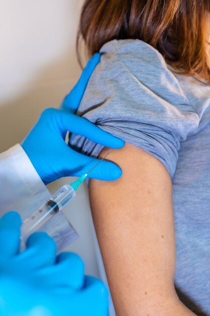 Femme médecin donnant le vaccin contre le coronavirus à une jeune femme enceinte. Anticorps, immuniser la population.