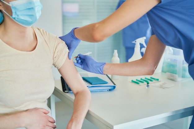 Une femme médecin donne une vaccination à un patient à la clinique.