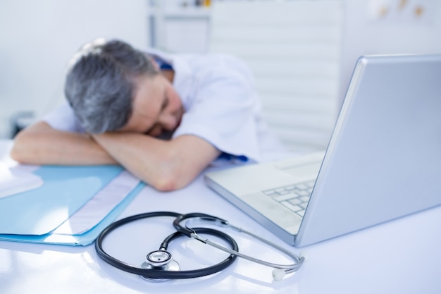 Photo femme médecin dormant sur le bureau