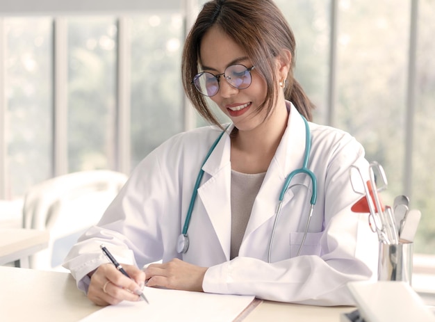 Une femme médecin écrit sur du papier médical à l'hôpital