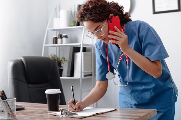 Femme médecin écrit avec un stylo sur un morceau de papier