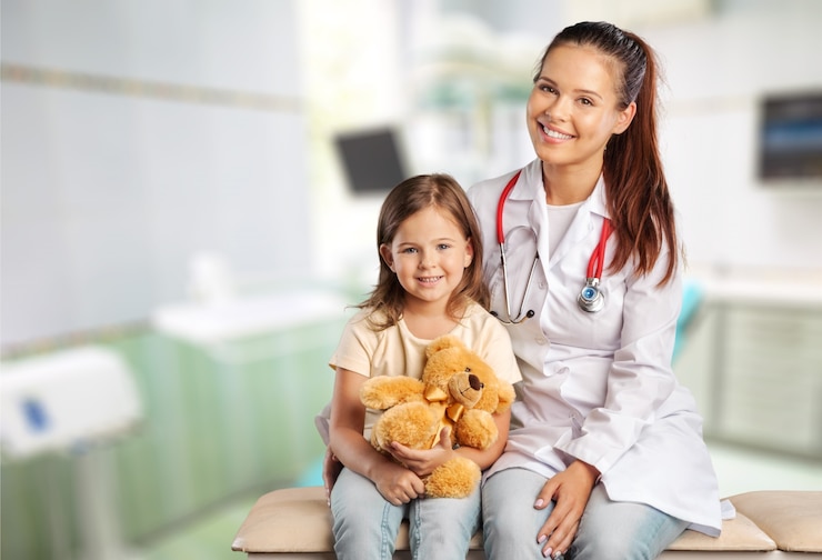 Photo femme médecin et enfant fille avec ours en peluche