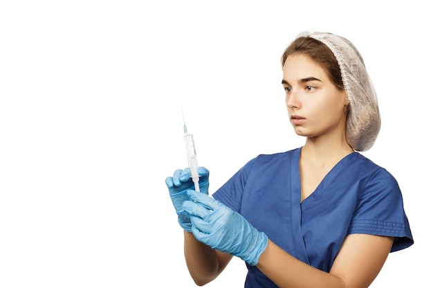 Une femme médecin en gants bleus et une blouse chirurgicale tient une seringue avec un médicament dans ses mains devant elle Concept de santé Anesthésie ou vaccin contre le virus et la maladie Soins médicaux hospitaliers