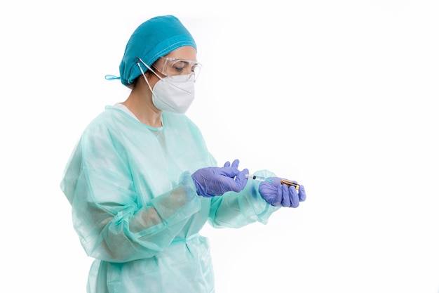 Femme médecin avec des gants et un masque préparant le vaccin sur fond blanc