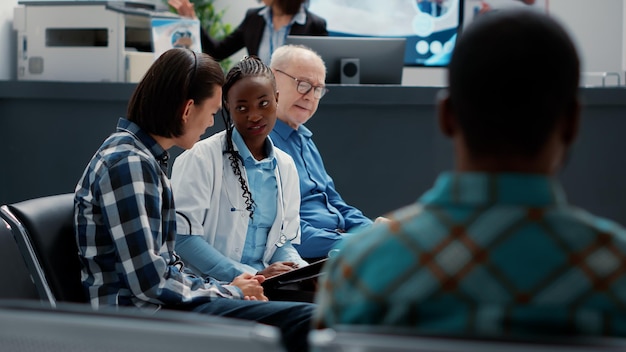 Photo femme médecin généraliste consultant une patiente asiatique dans le hall de la zone d'attente pour donner un diagnostic de maladie et un traitement de santé. médecin apportant son soutien à une personne malade à la réception de l'hôpital.