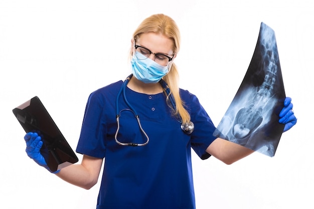 Femme médecin en gommage bleu étudie les rayons x avec pc