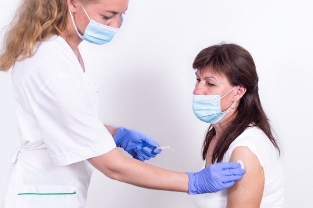 Femme médecin ou infirmière donnant une injection ou un vaccin aux patients, vaccination et prévention de l'épaule