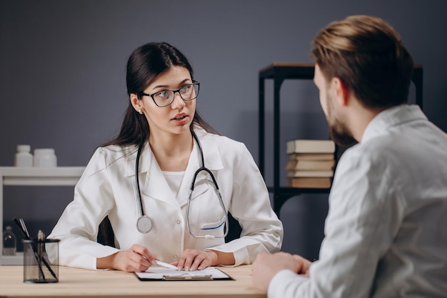 Une femme médecin interrogeant un patient masculin