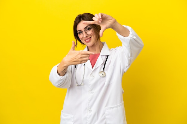 Femme médecin isolée sur fond jaune en se concentrant sur le visage. Symbole d'encadrement