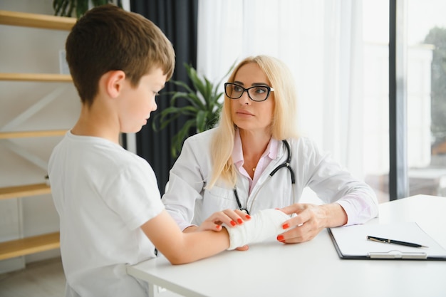 Femme médecin et jeune garçon avec un bras cassé