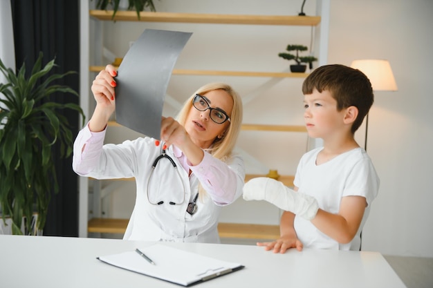 Femme médecin et jeune garçon avec un bras cassé