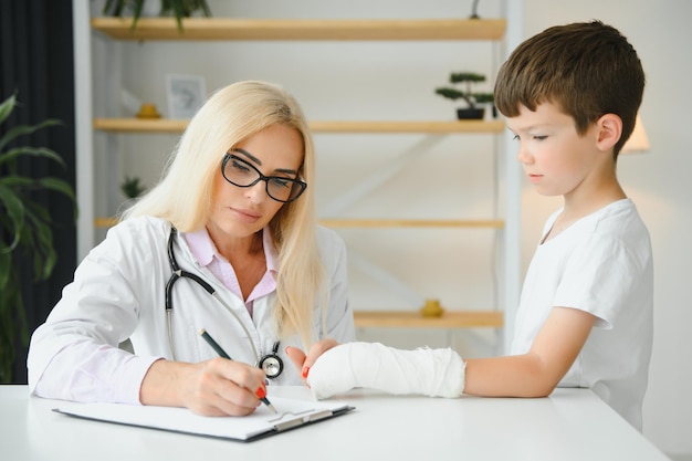 Femme médecin et jeune garçon avec un bras cassé