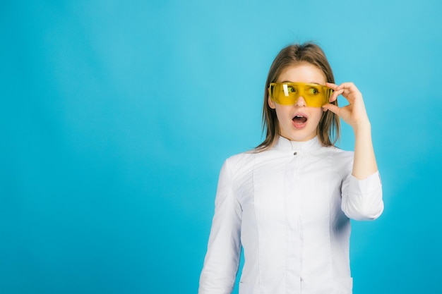 Femme médecin à lunettes jaunes sur fond bleu