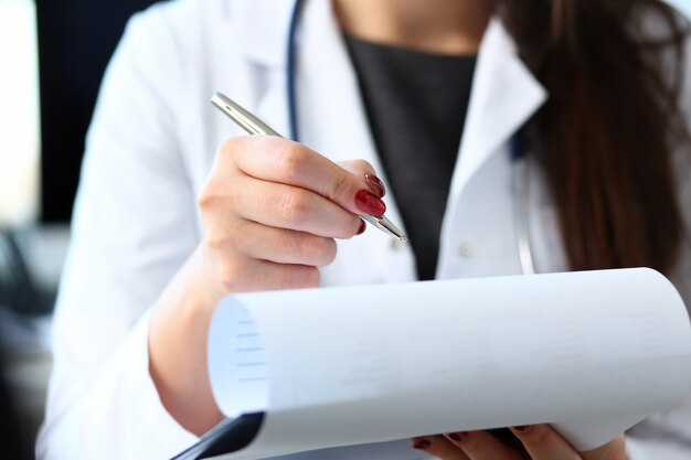 Femme médecin main tenir le stylo argent