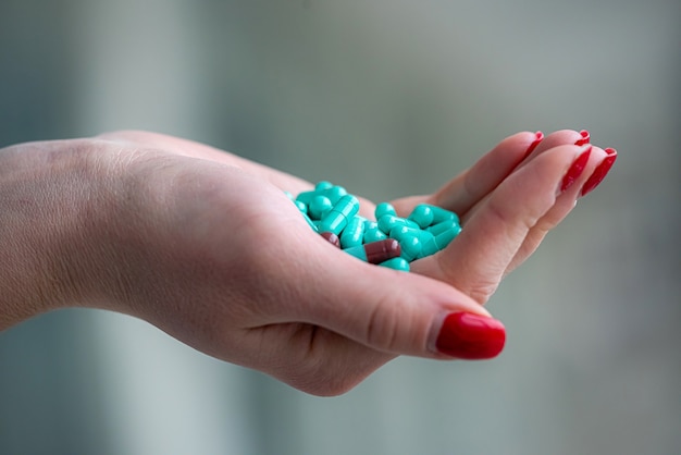 Femme médecin mains tenir traitement de pilules vertes